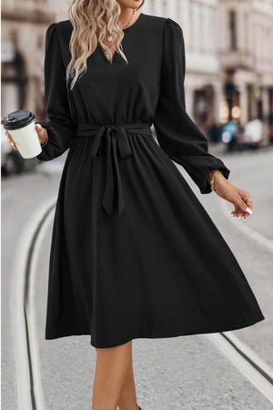 Black midi dress with poet sleeves, V-neck, and tie waist.