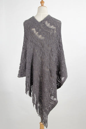 Dark gray crochet poncho with intricate openwork pattern and fringe detail.
