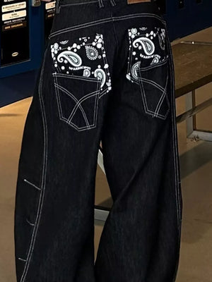 Relaxed fit dark wash denim cargo jeans with contrast stitching and paisley back pockets.