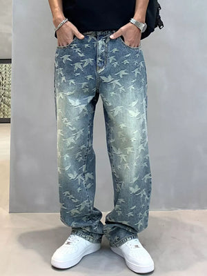 Loose-fit denim jeans with all-over bird print in light wash blue cotton.
