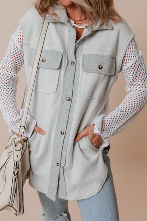 Light gray cotton utility vest with contrast trim and button-down front pockets.