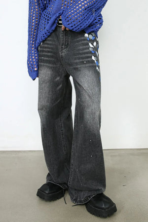 Painterly flare jeans in dark wash denim with artistic paint splatters and a wide leg.