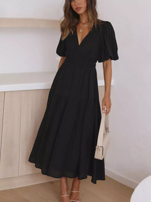Black midi dress with V-neck, puff sleeves, smocked waist, and tiered skirt.