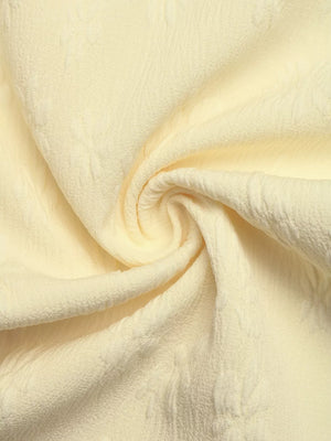 Chic Tie Strap Wide-leg Jumpsuit in pale yellow textured fabric with subtle floral pattern.