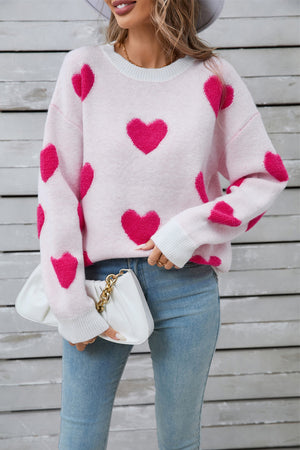 White crewneck sweater with hot pink heart appliqué, casual knit style.