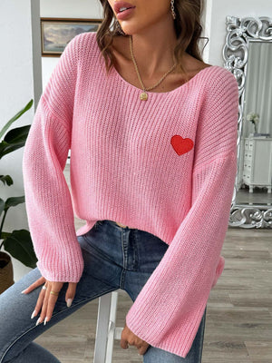 Pink slouchy boatneck knit sweater with embroidered red heart detail.