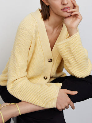 Yellow ribbed raglan cardigan with deep V-neck and button closure.