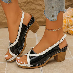 Black and white open-toe block heel sandals with adjustable ankle strap.