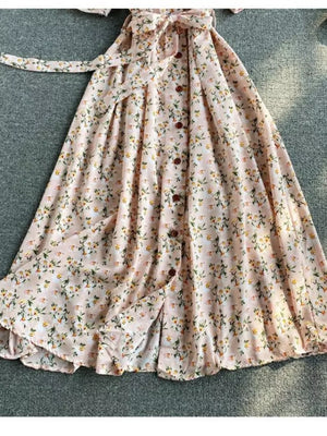 Pink floral midi dress with V-neck, button front, belted waist, and ruffled hem.