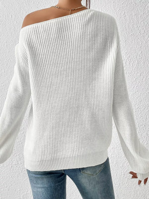 White asymmetrical knit sweater with off-shoulder neckline and long sleeves.