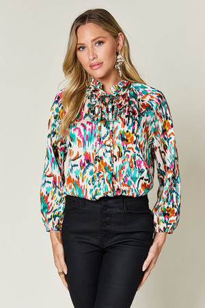 Silk tie-neck blouse with abstract ikat print and button front.