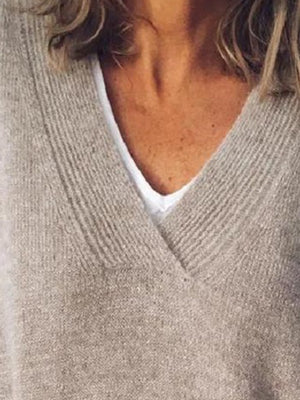 Relaxed V-neck ribbed knit sweater in tan, layered over a white top.