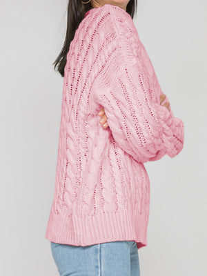 Cable knit openwork sweater in Carnation Pink acrylic with crew neck and long sleeves.