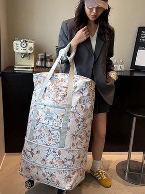 Charming floral rolling travel bag in white with a delicate botanical print, featuring wheels and handles for easy transport.