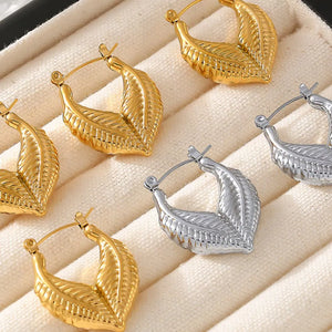 Textured gold leaf hoop earrings in gold and silver finishes.