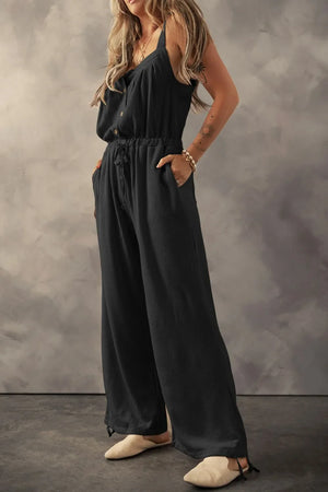 Black waffle knit wide leg jumpsuit with drawstring waist and buttoned front.