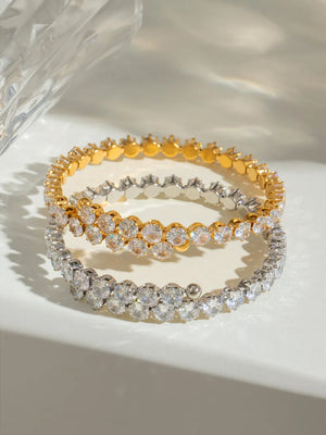Double row pavé bangle bracelets in silver and gold with clear cubic zirconia stones.