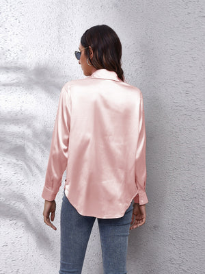 Silken button-down shirt in blush pink with a relaxed fit and button cuffs.