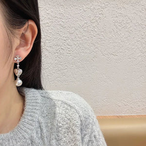 Sophisticated pearl heart drop earrings with a cross detail in silver.