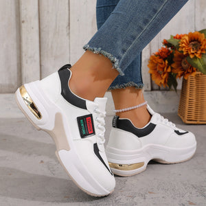 White and black lace-up sneakers with chunky soles and gold accents.