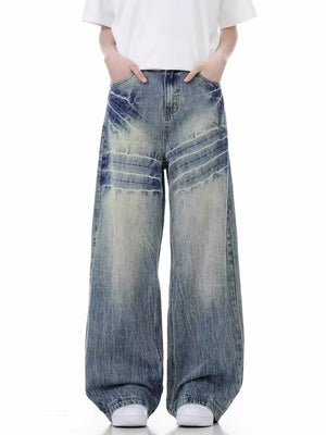 Men's distressed vintage wide-leg jeans in washed blue denim with faded details.
