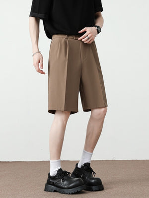 Men's light brown pleated detail loose-fit chino shorts with a relaxed cut.