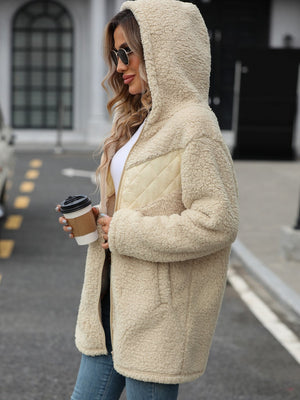 Cream teddy hoodie with quilted panel detail and zip front, worn open.