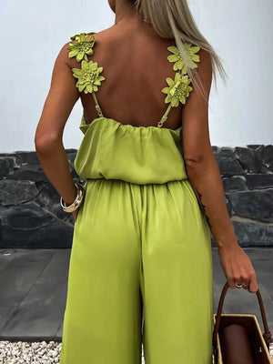 Yellow green wide-leg jumpsuit with floral applique straps and blouson top.