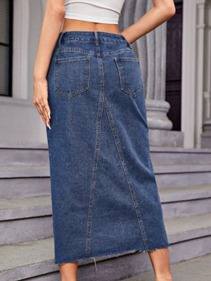 Denim maxi skirt in medium wash cotton with front seam detail and raw hem.