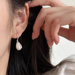 Lustrous pearl drop earrings in silver with a delicate petal design.