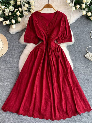 Crimson lace-embellished midi dress with V-neck, puff sleeves, and button detail.