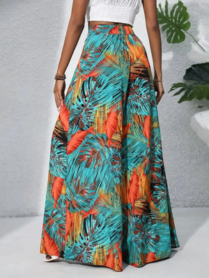 Palazzo trousers in tropical leaf print, teal, orange-red, and white.