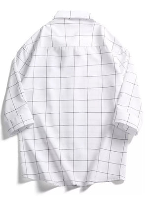 White oversized cotton button-down shirt with black plaid print and collar.