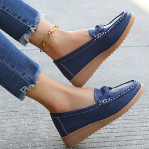 Dark blue leather loafers with braided detail and white stitching.