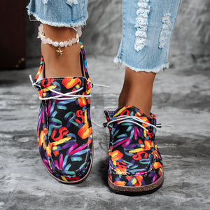 Printed casual slip-on loafers with abstract brushstroke pattern in black and multicolor.