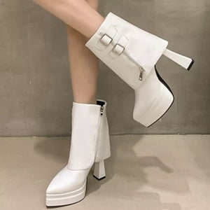 White ankle boots with pointed toe, block heel, platform, zipper and buckle straps.