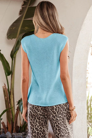 Light blue knit V-neck sweater vest with button details, styled with leopard print pants.