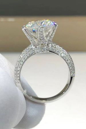 Silver pavé band moissanite solitaire ring with a large, brilliant-cut center stone.