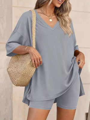 Gray V-neck two-piece set with loose-fit top and biker shorts, styled with a straw bag.