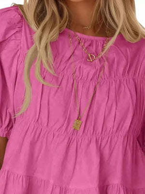 Rose pink maternity blouse with puff sleeves, ruffled tiers, and smocked bodice detail.