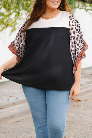 Colorblock waffle knit top with leopard print flutter sleeves and black bodice.