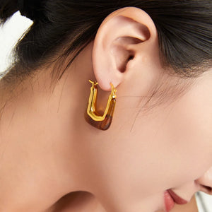Gold geometric hoop earrings with amber resin detail