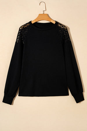 Black waffle knit raglan top with lace yoke detail and long sleeves.