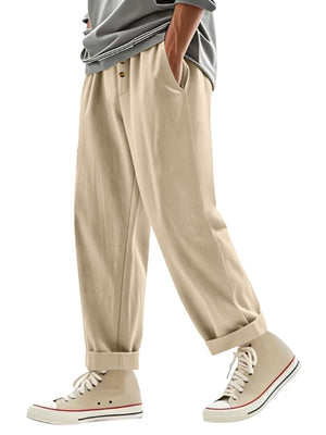 Men's light khaki loose fit drawstring pants with button detail and cuffed hems.