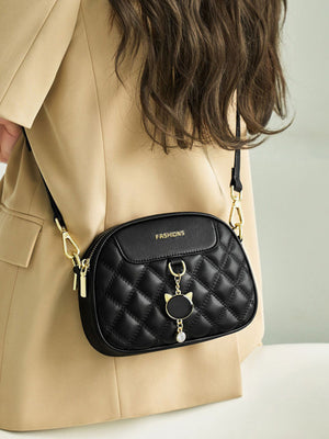 Black quilted PU leather crossbody bag with cat charm and gold hardware.