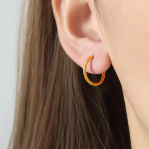 Gold vermeil huggie earrings, minimalist hoop style, on ear