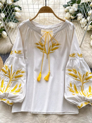 White embroidered tie-neck blouse with yellow wheat detail and tassel ties.
