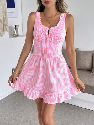 Pink gingham mini dress with sweetheart neckline, lace trim, and ruffled hem.
