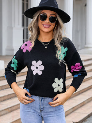 Black crewneck sweater with colorful floral print, long sleeves, acrylic knit.