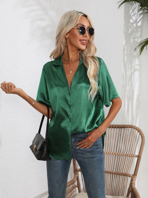 Dark green satin collared shirt with short sleeves and button front, styled with jeans.